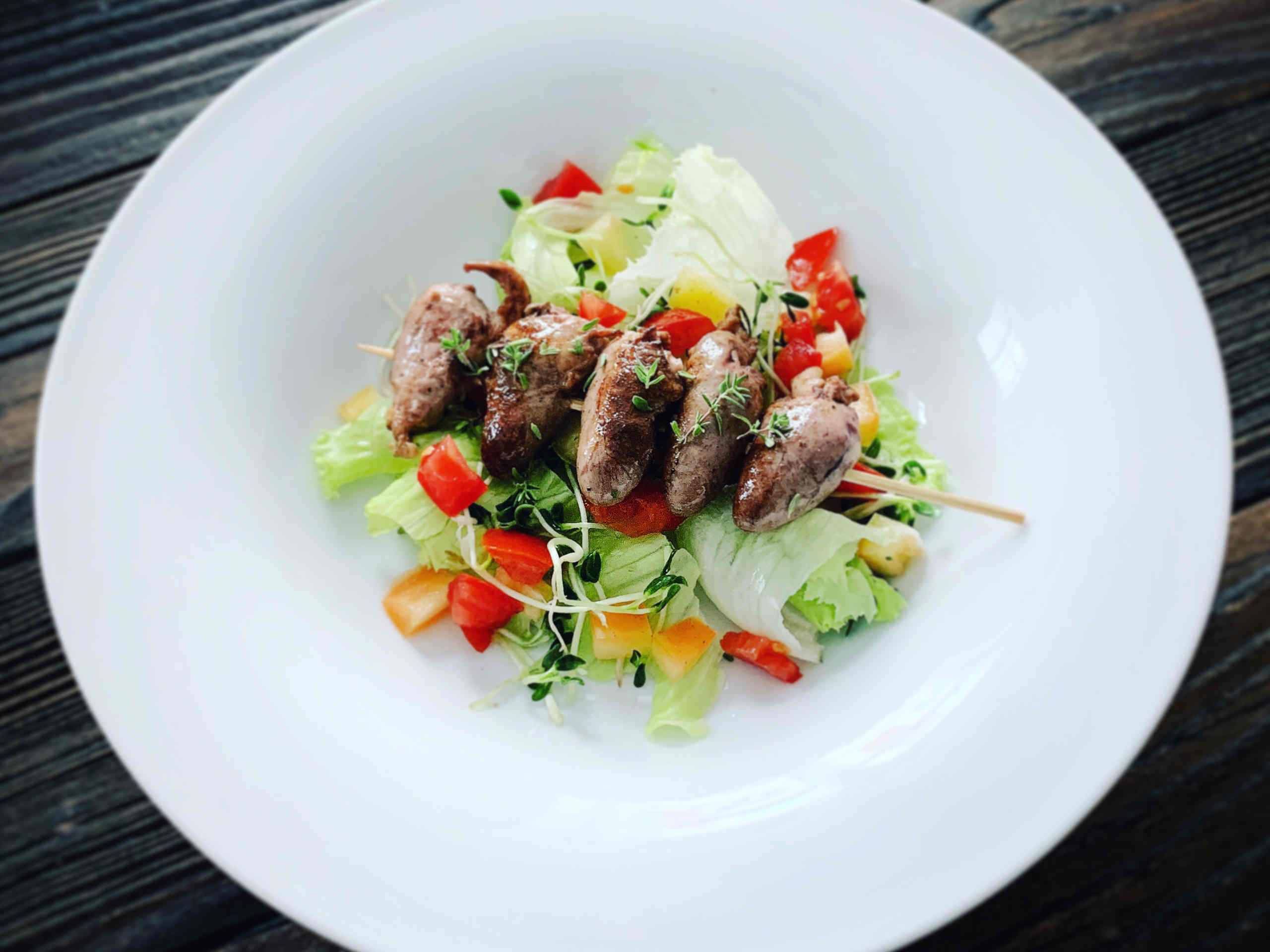 Chicken hearts on mixed salad with fenugreek sprouts